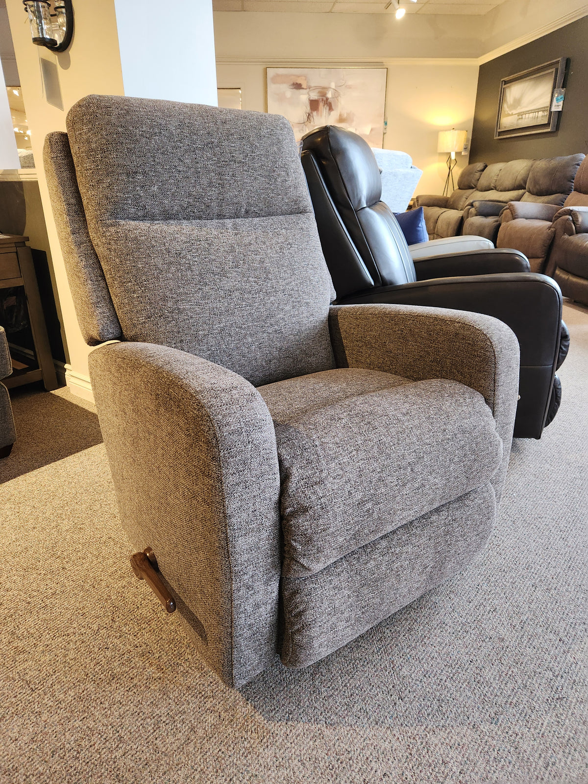 The La-Z-Boy 747 Finley Rocker Recliner showcases its modern design and gray comfort in the showroom.