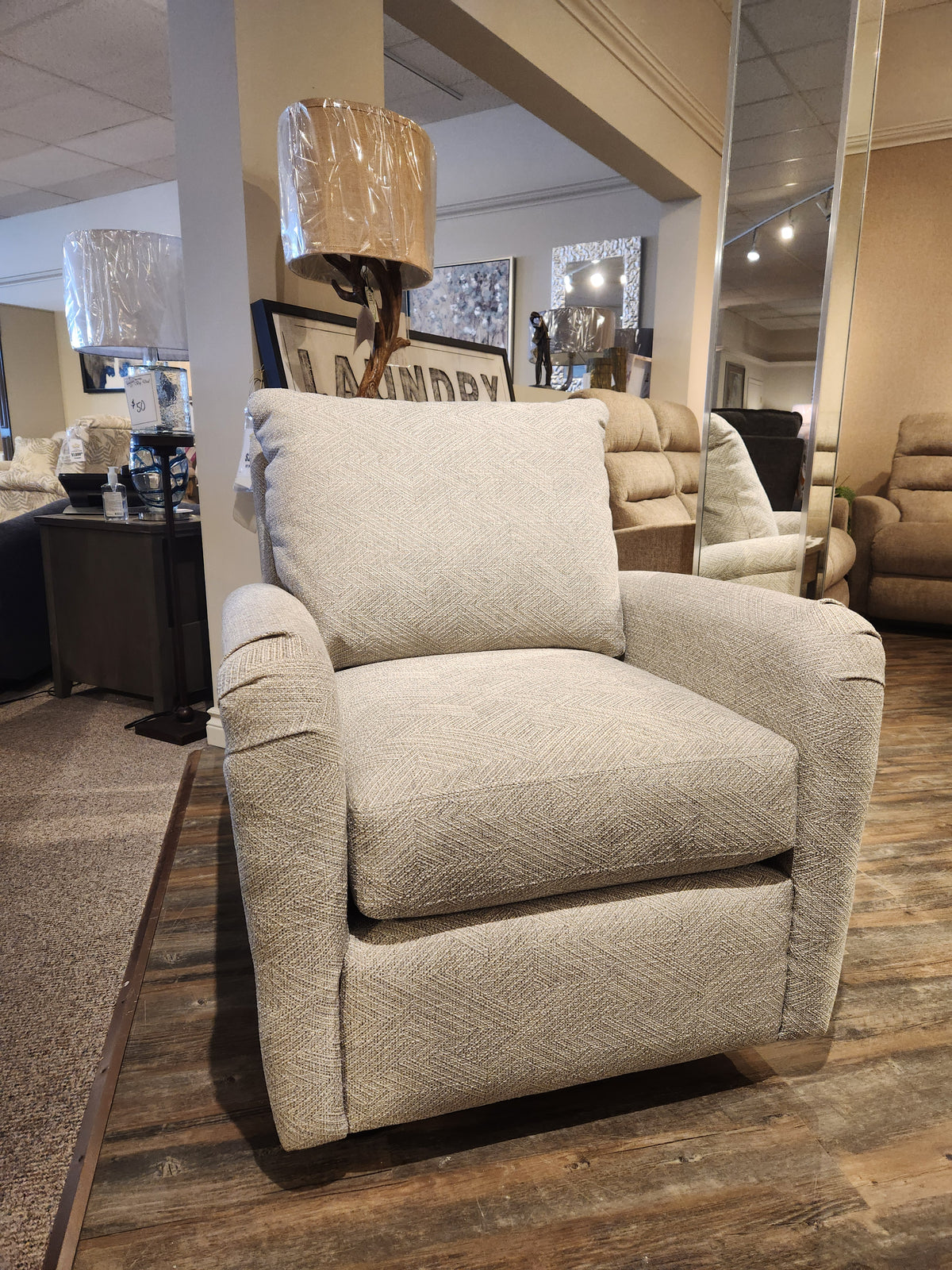 The showroom features the 425 Alma Swivel Glider Chair by La-Z-Boy, surrounded by decor and other furniture.