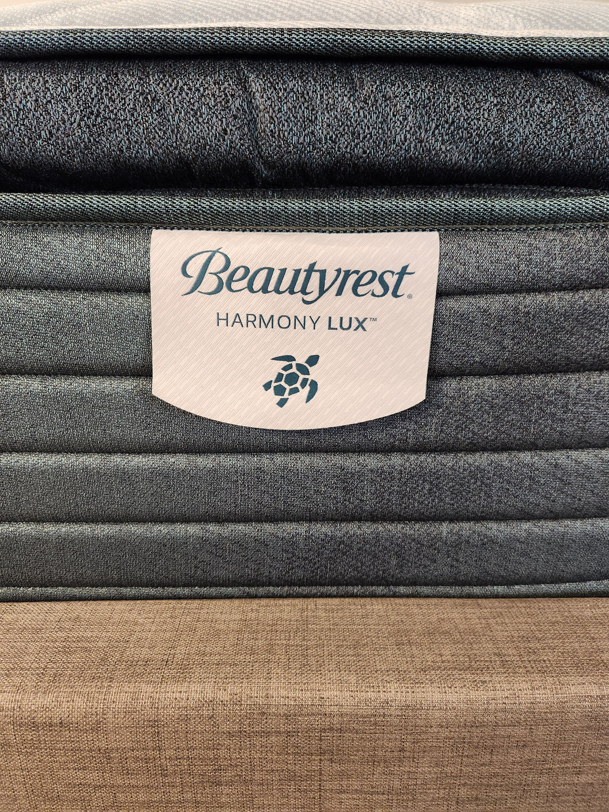 Close-up of the Beauty-rest Glacier Grove Pillow Top Plush label, showcasing fabric and stitching details.