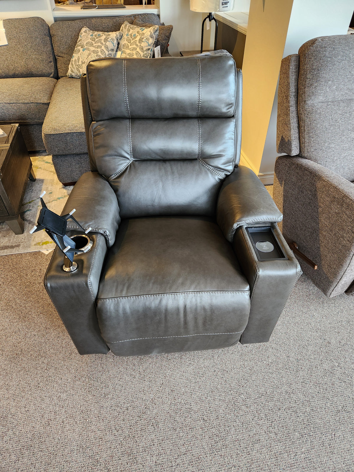 Gray Neo Power Rocker Recliner by La-Z-Boy with adjustable headrest and cup holders on a carpeted showroom floor.