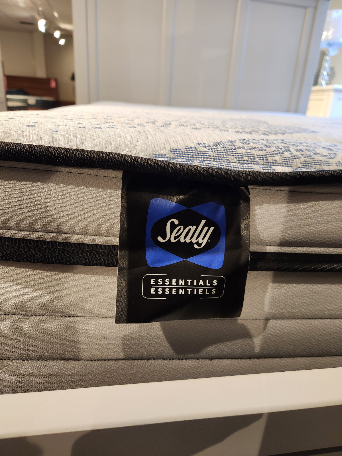 Close-up of a Bridget ET Firm Mattress tag showcasing Certipur-US certified gel HD foam by Sealy in a showroom.