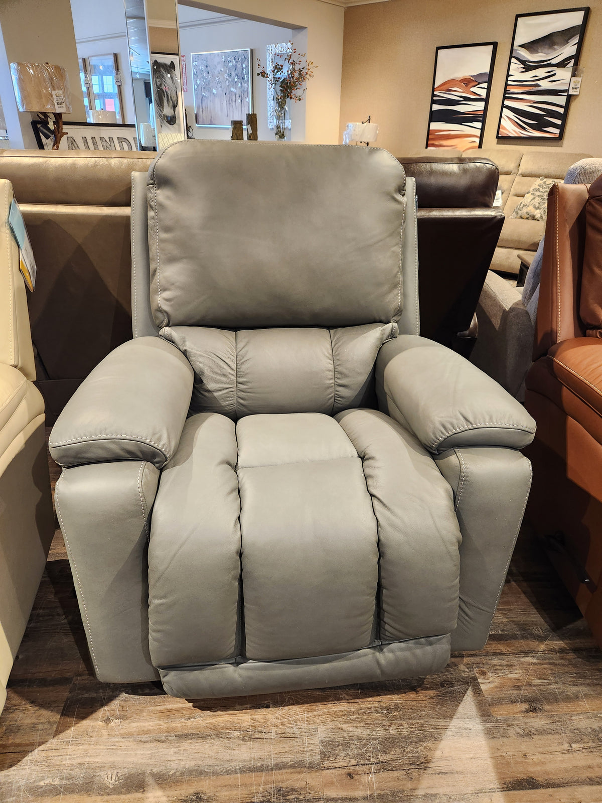 The La-z-boy 530 Greyson Recliner features padded armrests, a high backrest, and a sleek power recline in a showroom.