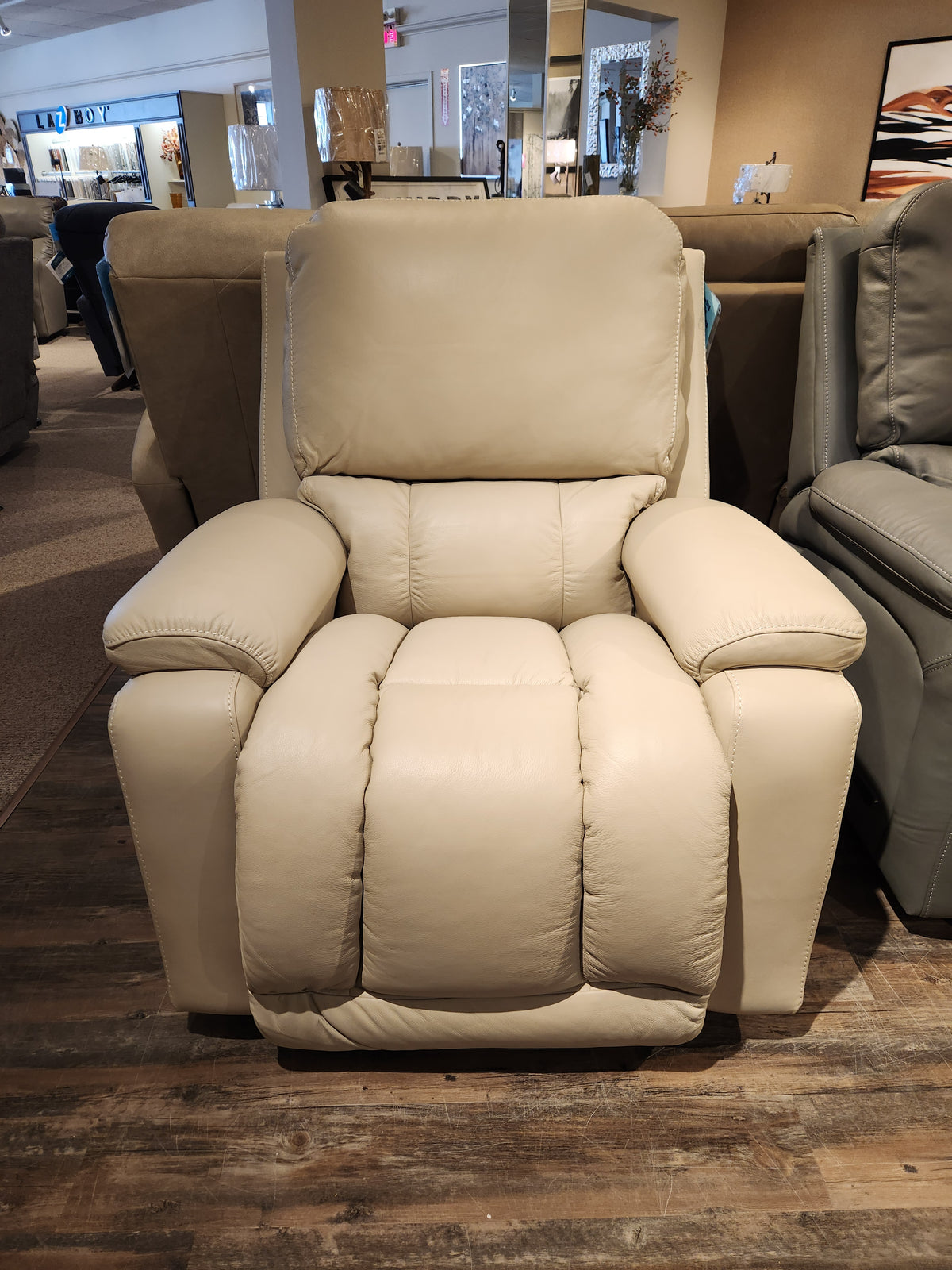 The 530 Greyson Wall-a-Way Recliner by La-z-boy, complete with a power recline feature, is elegantly displayed in a furniture store among a variety of other seating options.