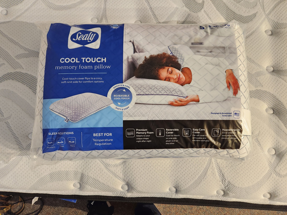 The packaging for the Sealy Cool Touch Memory Foam Pillow by Sealy features an image of someone sleeping peacefully, emphasizing the comfort provided by its premium memory foam. The pillow's reversible cover and advanced temperature regulation technology work together to keep you cool all night long.