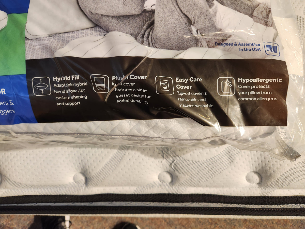 Close-up of the Sealy Custom Comfort Pillow packaging highlighting features: hybrid fill, plush cover, easy-care zip-off machine washable cover, and hypoallergenic protection. Ideal for side sleepers seeking comfort and support.