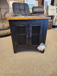 Ashley Valebeck T468 End Table with wire mesh doors and wooden top, featured in a furniture store.