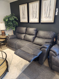 A 724 Trouper Power Reclining Sofa with Headrest by La-Z-Boy, upholstered in gray, with plush cushions and convenient built-in USB ports, is arranged in a living room setting beside framed art and a side table.