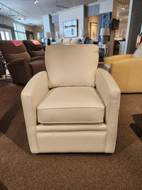 The Superstyle 37-59C Swivel Chair, featuring elegant white upholstery, is showcased in a furniture showroom, providing comfortable support amid an array of chairs and decor in the background.