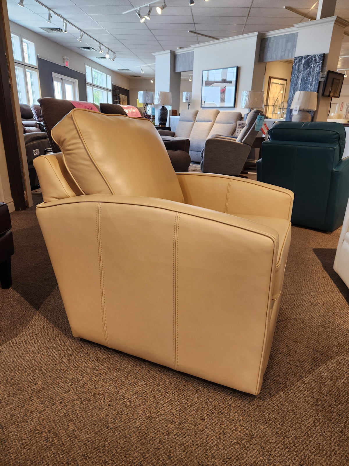 A Superstyle 37-59C Swivel Chair, crafted from beige leather and designed to provide comfortable support, is featured in a furniture store amidst an array of chairs and sofas.