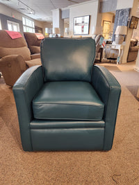 The 37-59C Swivel Chair by Superstyle is showcased in a furniture store showroom, accompanied by other chairs and lamps in the background, providing comfortable support for any setting with its sleek teal leather design.