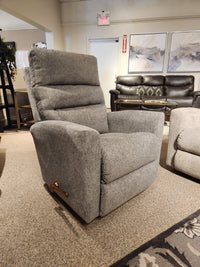 Elevate your living space and experience unparalleled comfort with the 786 Liam Rocker Recliner by La-Z-Boy, now available in our showroom. This gray recliner melds casual style with relaxation, inviting you to unwind while surrounded by striking wall paintings.