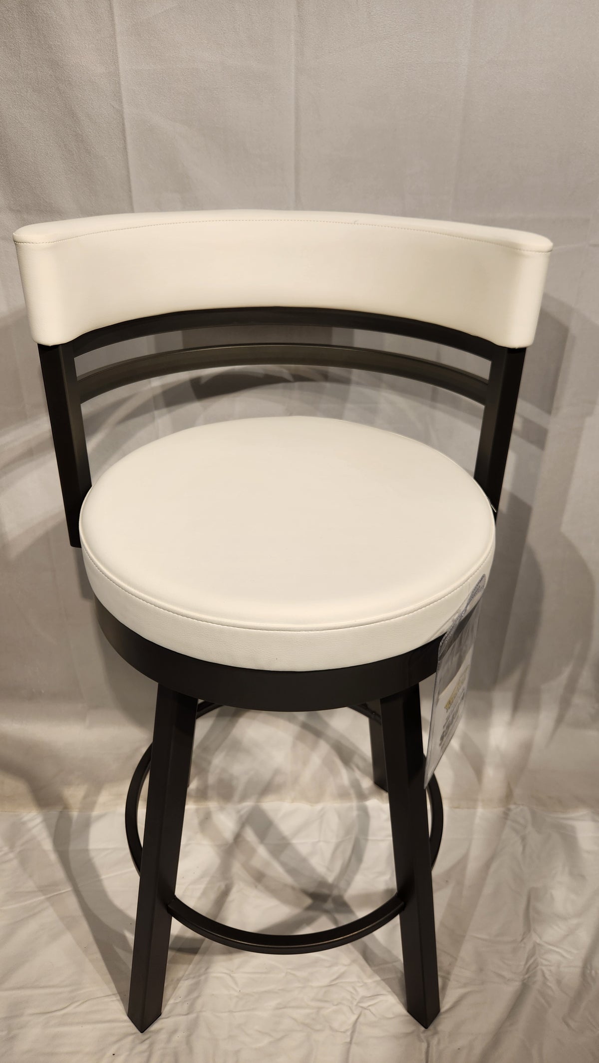 The Ronny Swivel Stool by Amisco: white, round seat with a curved backrest and gleaming metal accents.