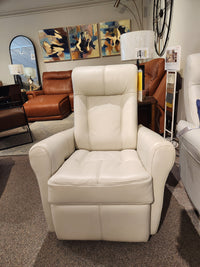 The 42201 Yellowstone I Rocker Recliner by Palliser is displayed in a furniture showroom, highlighting its Scandinavian design against a backdrop of artwork and other furniture.