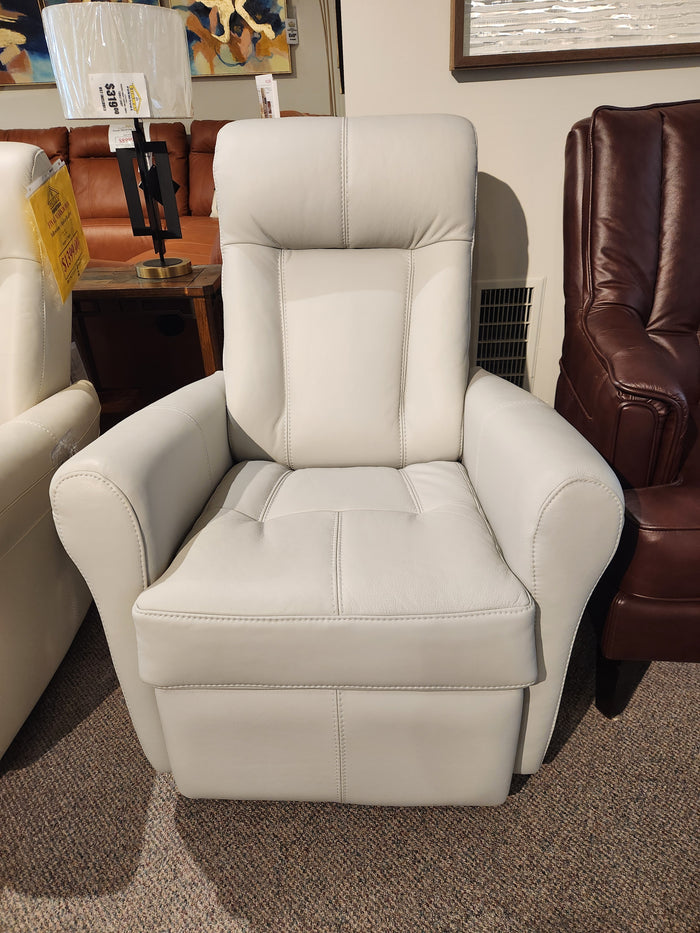 The Palliser 42201 Yellowstone I Rocker Recliner, featuring a white leather finish, is showcased in the showroom, exuding ergonomic comfort alongside a brown recliner and table.