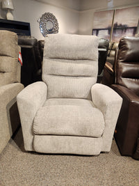 The 786 Liam Rocker Recliner by La-Z-Boy, featuring its gray upholstery, stands in the showroom exuding casual style. Surrounded by other chairs and bathed in soft lighting, it invites comfort and relaxation.