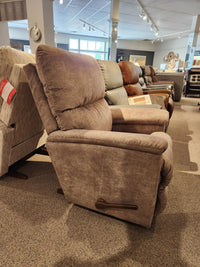 A row of recliner chairs on display in a showroom showcases the 727 Brooks Rocker Recliner by La-Z-Boy, featuring a modern silhouette and prioritizing comfort, with a brown fabric recliner prominently positioned in the foreground.