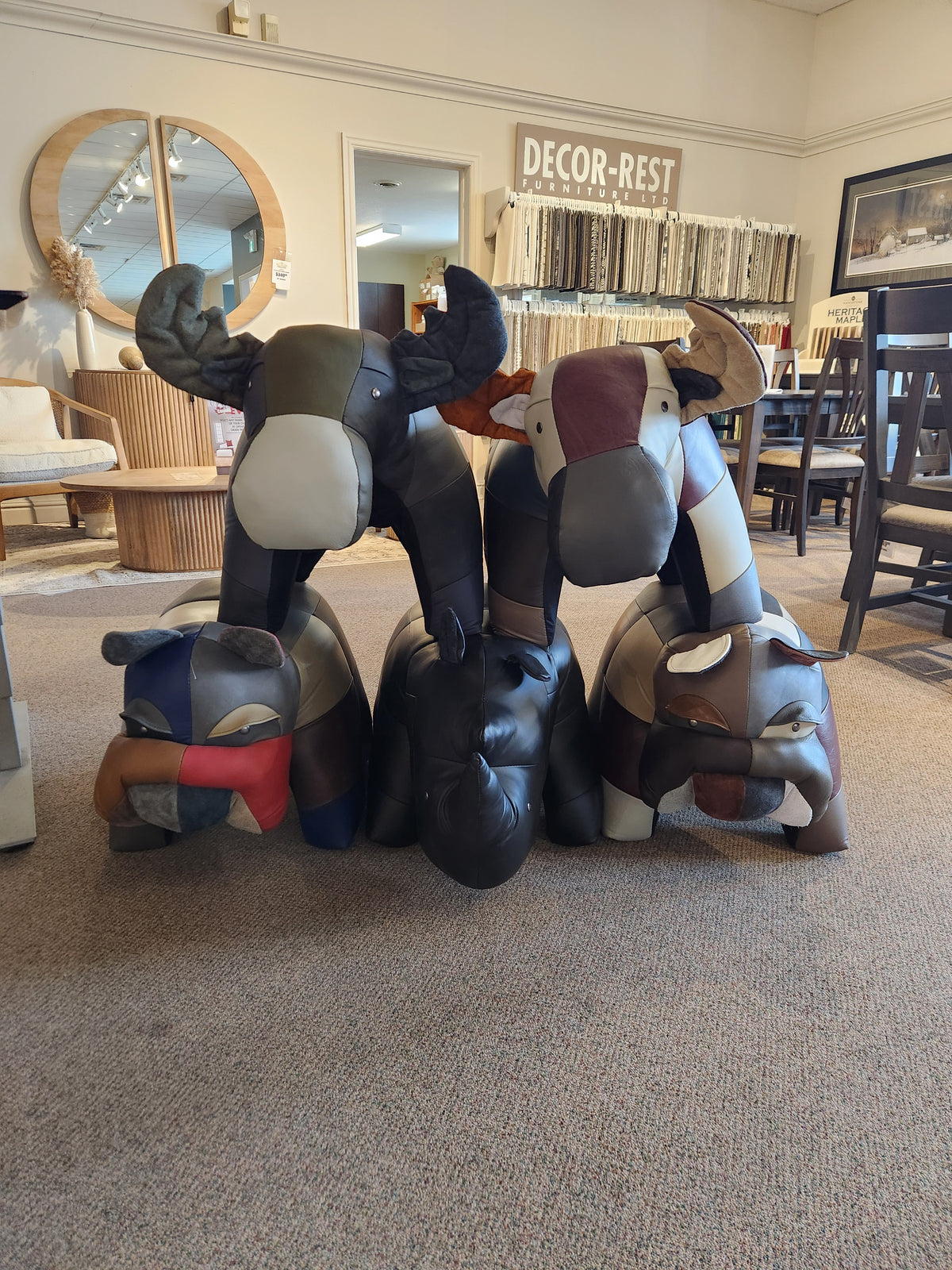 Reiner's Originals presents the Reiner's Leather Animal Ottomans, featuring a unique showroom design with four captivating fabric sculptures: a moose, moose head, elephant, and bulldog. These charming ottomans add a touch of style to any space.