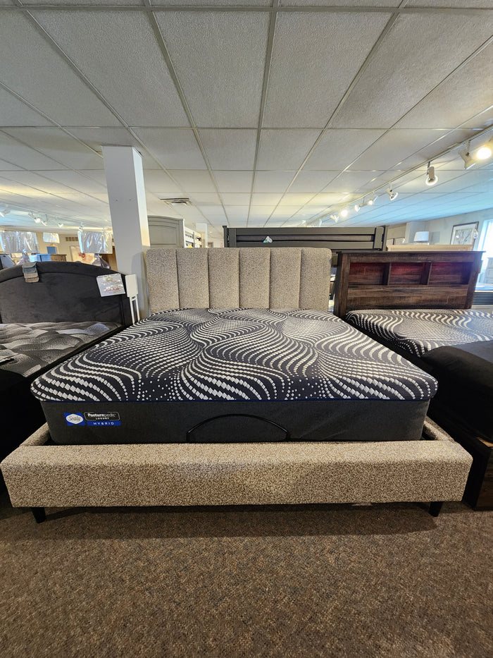 In the showroom, a Palliser 77140 Verttia Power-Adjustable King Bed with a patterned mattress sits on the carpeted floor.