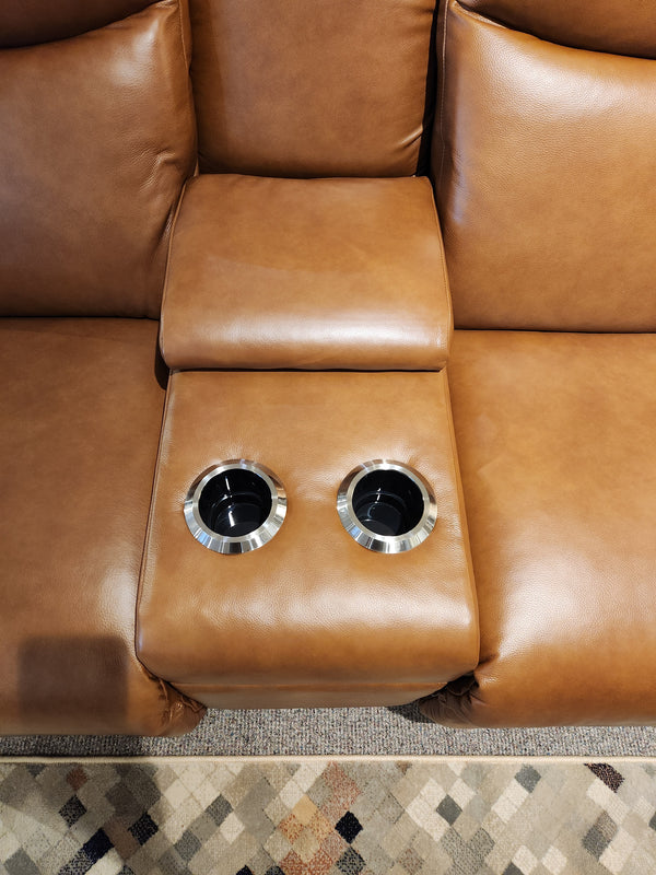 La-Z-Boy's 781 Emmons Power Reclining Loveseat with Headrest features rich brown leather and plush backs, complemented by a middle section equipped with two cup holders on the armrest, perfectly paired with a patterned rug for ultimate comfort.