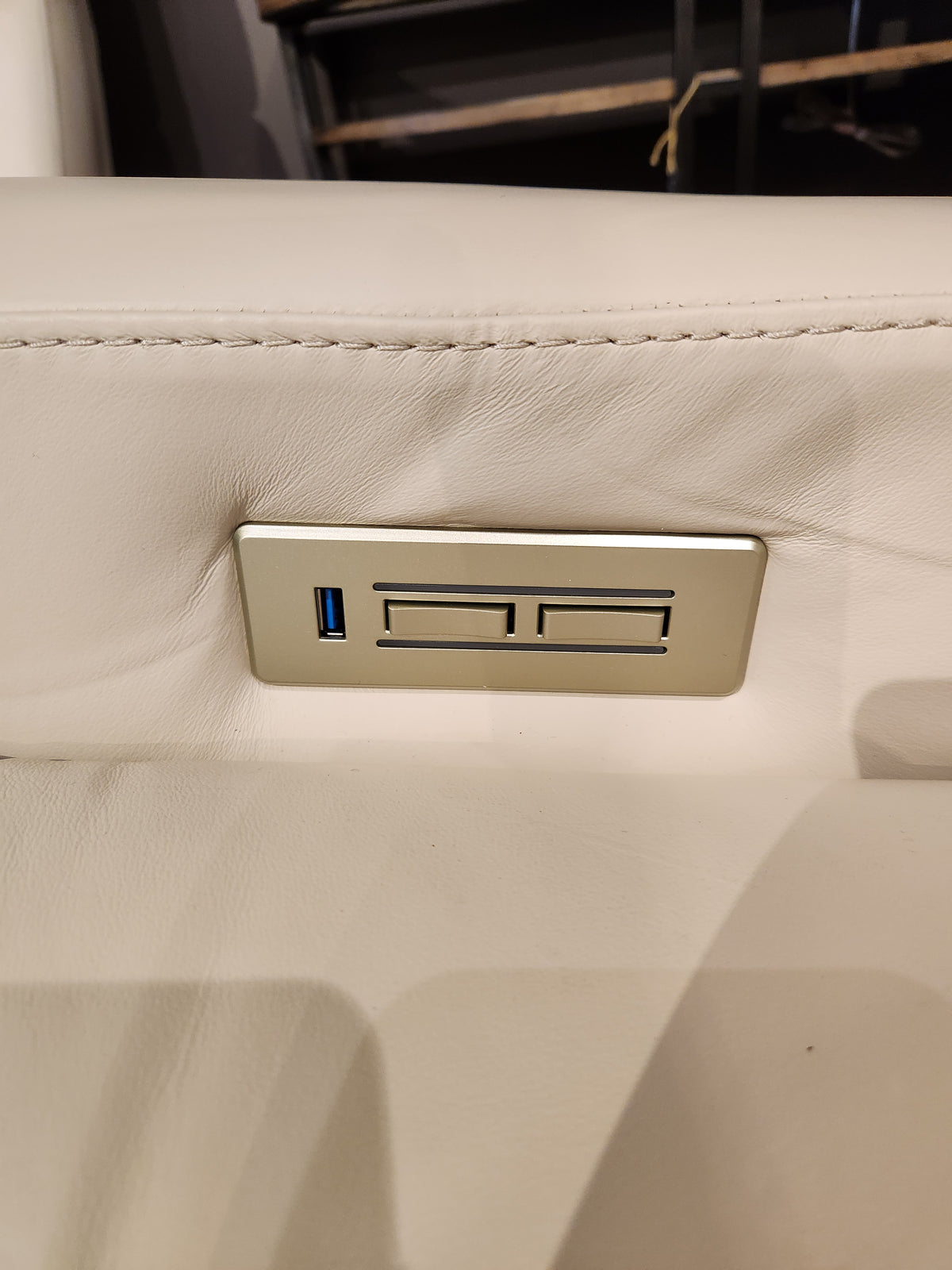 Close-up of USB port and two buttons on the white leather Palliser 42204 West Coast Power Reclining Loveseat With Headrest.