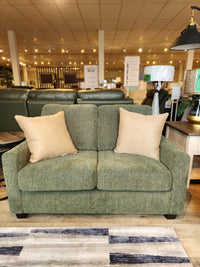 Superstyle's 7002 Loveseat, with beige pillows, is showcased with lamps and a patterned rug in a Canadian furniture store.