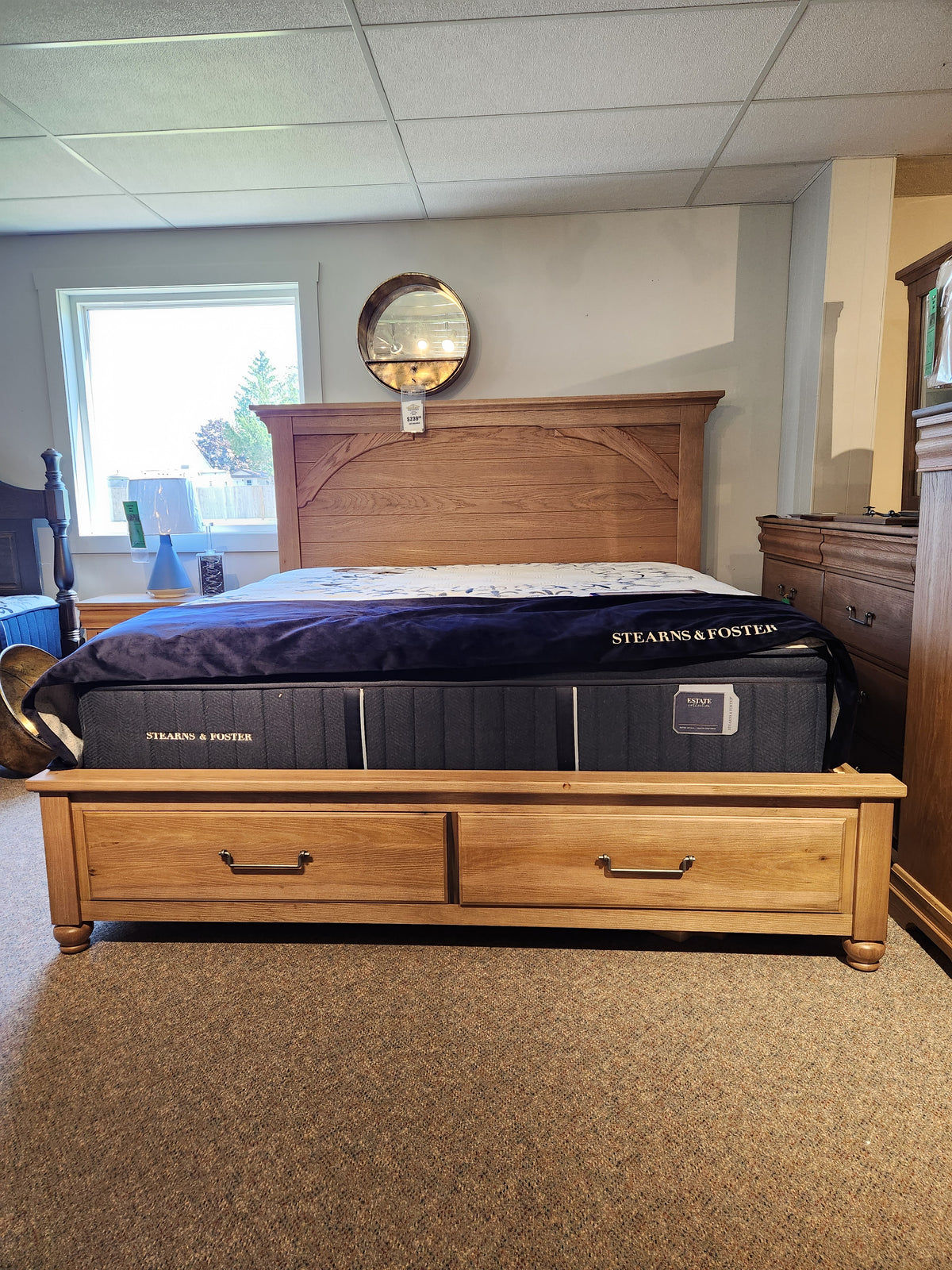 Vaughan Bassett's 771 Vista Mansion King Storage Bed with a Stearns & Foster mattress and a mirror above for a rustic feel.