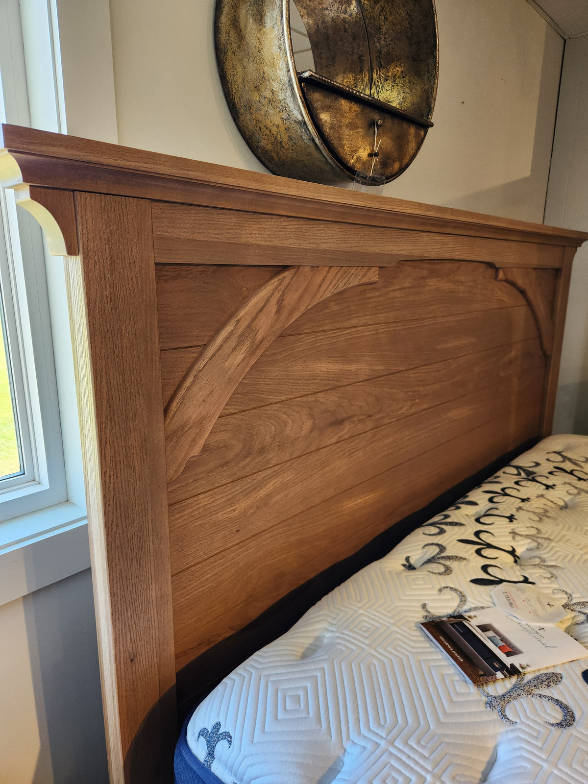 Vaughan Bassett's 771 Vista Mansion King Storage Bed features a rustic headboard with storage, paired with round wall decor.