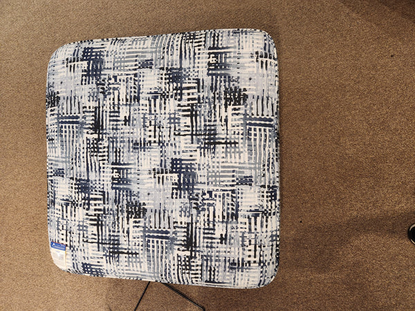 Palliser 77004 Mingle Medium Square Ottoman with blue and white abstract pattern on a brown carpeted floor.