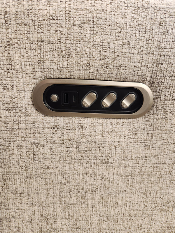 Close-up of a beige textured wall panel next to the M8500 Power Reclining Sofa by Decor-rest, showcasing a control unit with three switches and a USB port.