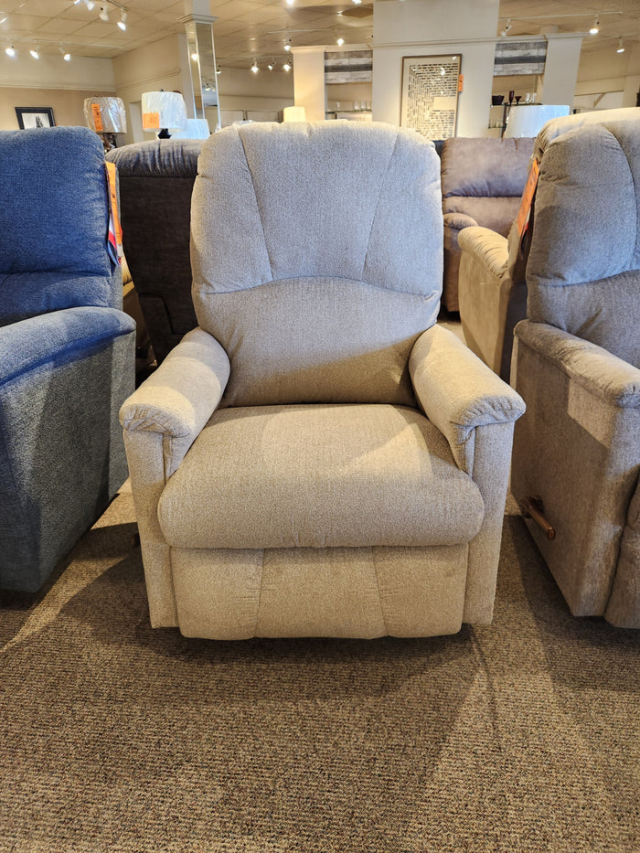 A La-Z-Boy 795 Mercury Rocker Recliner in beige exudes comfort among chairs on a carpeted showroom floor.