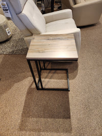 Handstone's AlaCarte Snack Table sits in front of a beige recliner on a carpeted showroom floor.