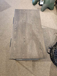 Handstone's Muskoka Coffee Table with a light brown oak top highlights its wood grain on a beige carpet.