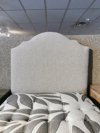 Vaughan Bassett Upholstered Twin Bed in showroom, showcasing a textured headboard and grey antelope fabric mattress accents.