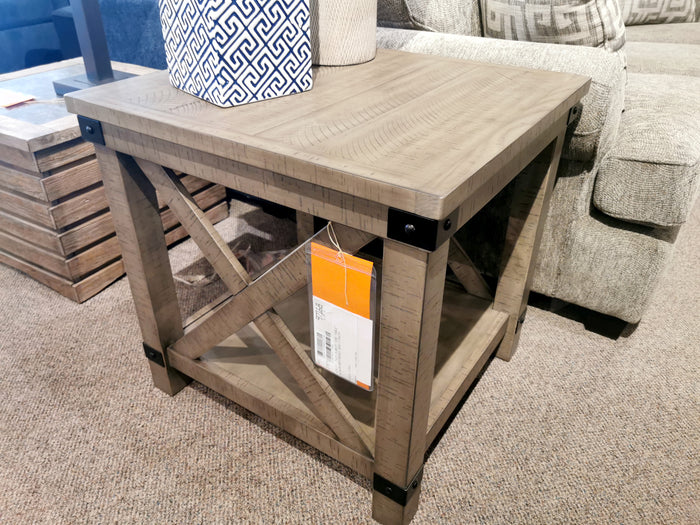 Ashley Aldwin End Table in weathered gray with crossbuck styling complements beige upholstered furniture.