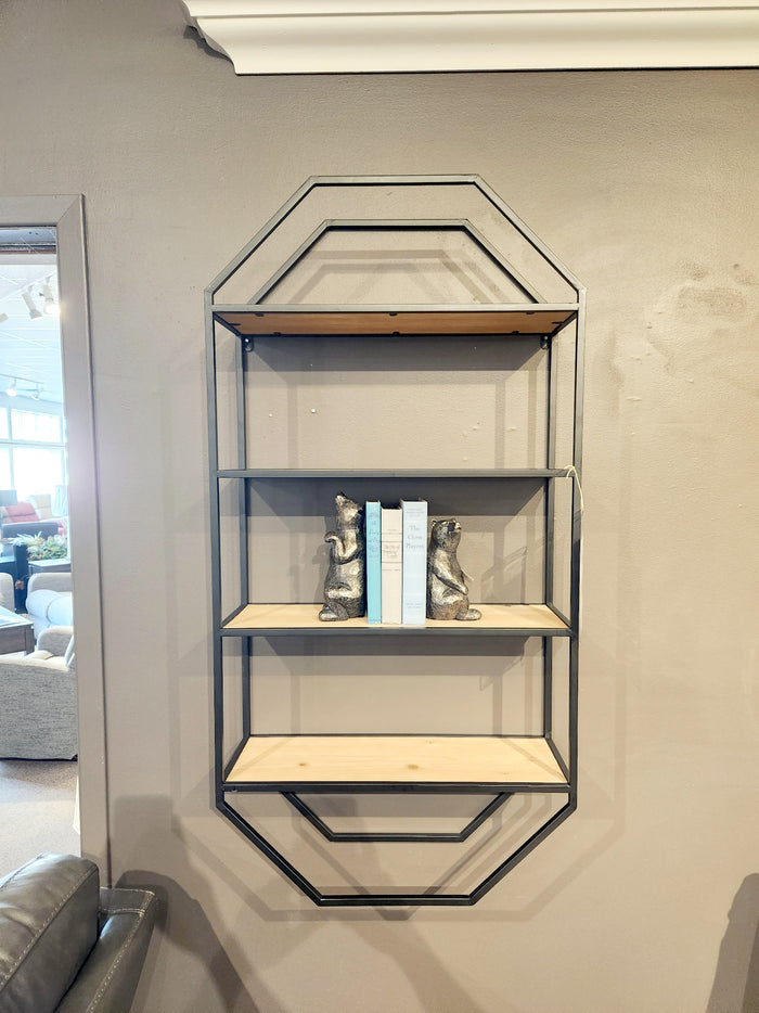 The Elea Wall Shelf by Ashley, showcasing a minimalistic geometric design with three levels, displays two metal dog sculptures and three books against a gray wall.