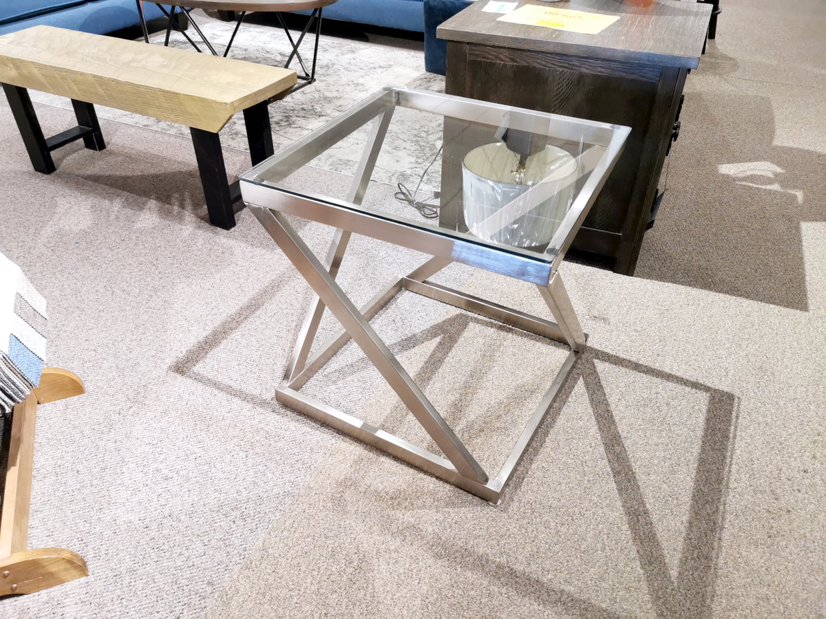 Ashley Coylin Square End Table with glass top and metal frame, elegantly displayed in a store setting.