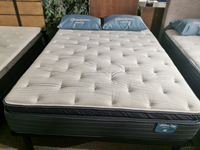 A neatly made bed with a white quilted mattress and pillow-top comfort, featuring two Beauty-rest Alcove Medium pillows.