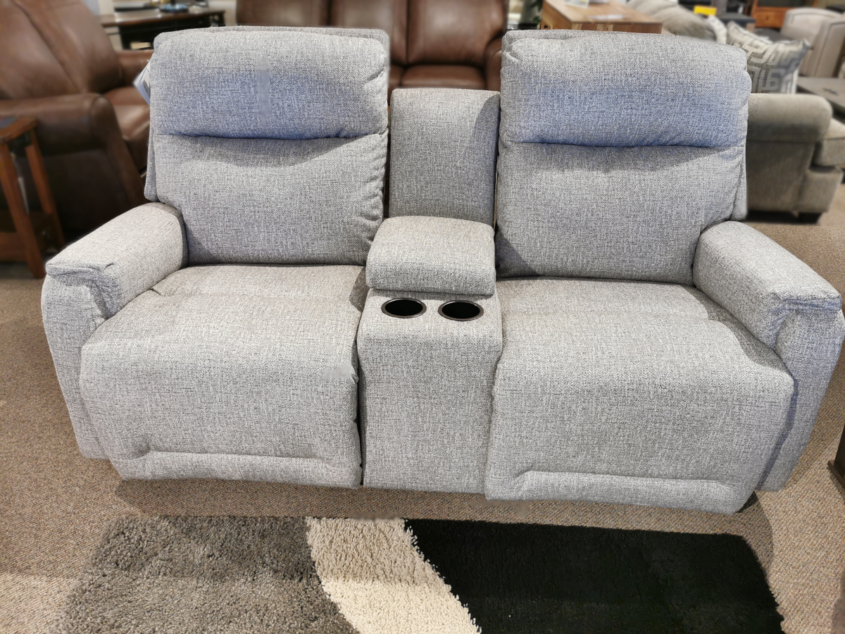 Gray L650RQ7 Derek Power Loveseat by Best with console and cup holders on a carpeted store floor.