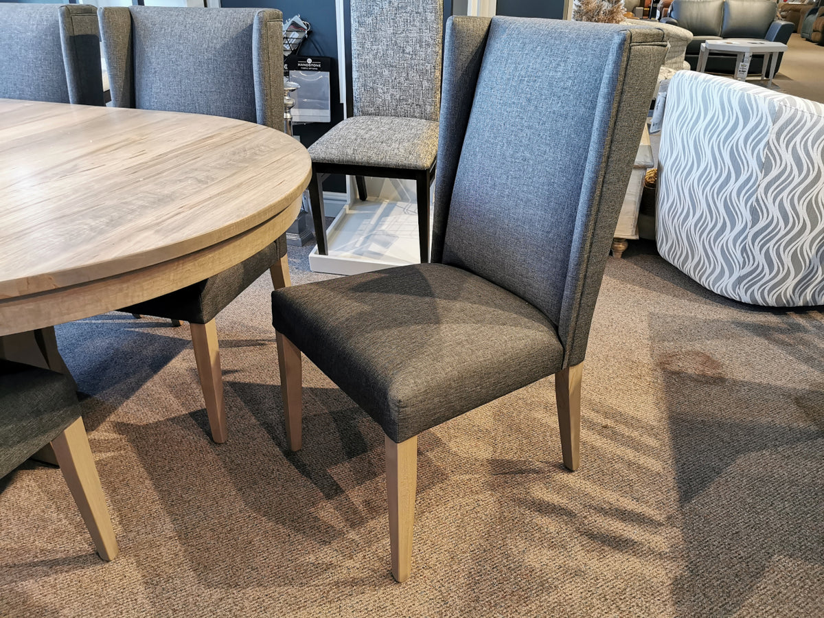 Handstone JA48 Jasper dining chair with wooden legs beside a round table on a carpeted showroom floor.