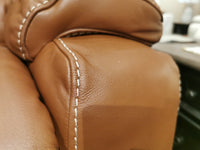 Close-up of 530 Greyson Rocker Recliner by La-Z-Boy showing brown leather with white stitching on armrest.