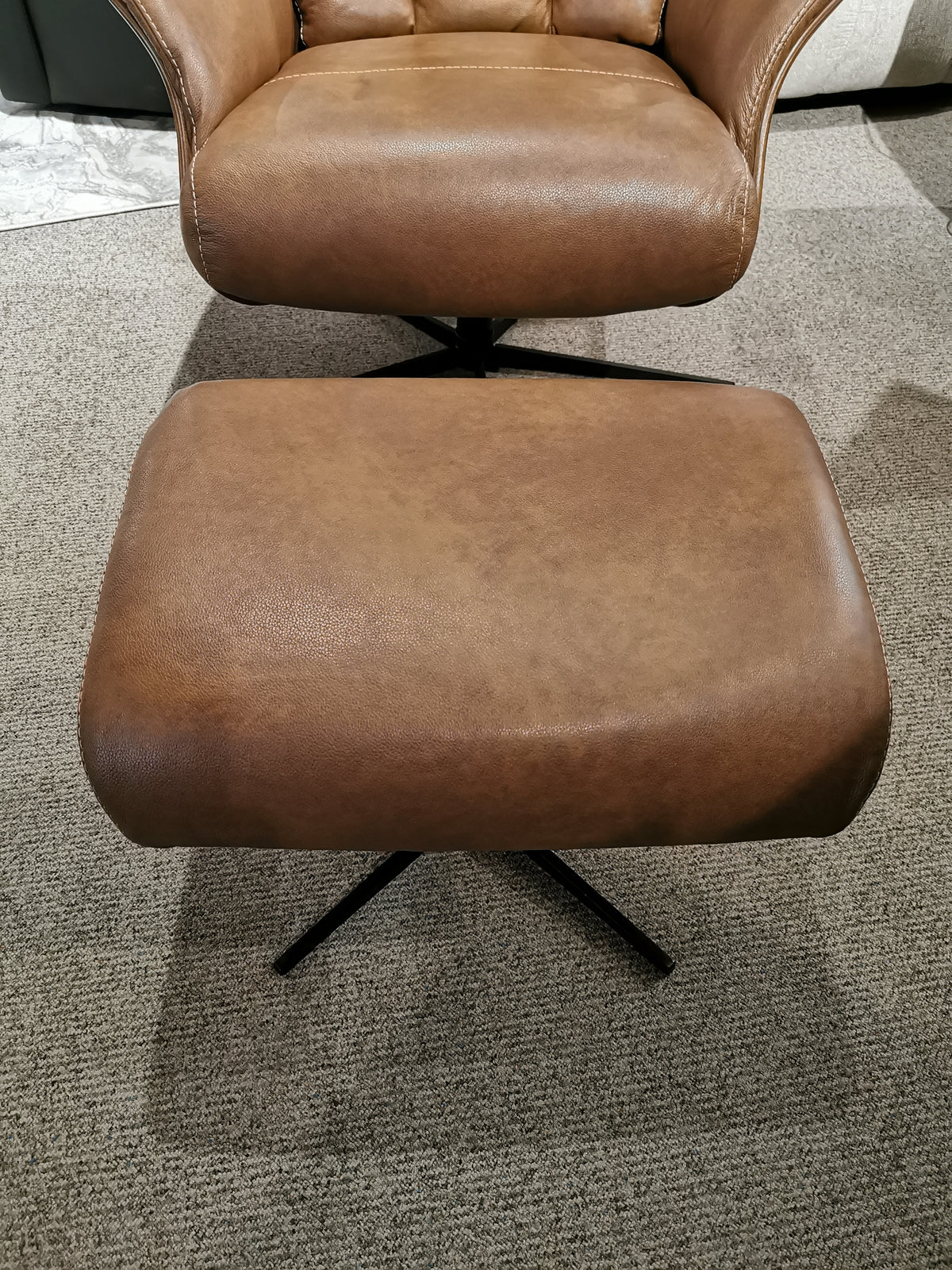 Vilma Recliner with Ottoman, a Brown Italian leather chair by Donald Choi, resting on a carpeted floor and featuring a sleek motion Italia mechanism.