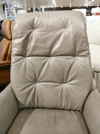 The Vega Power Recliner by Donald Choi, featuring premium Italian leather, a tufted backrest, and high-density foam cushioning, is on display in a showroom.