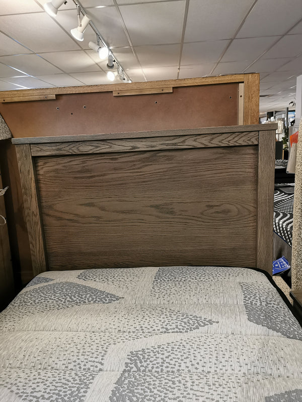 11 Fundamental Panel Twin Bed by Vaughan Bassett with a gray and white bedspread in a furniture store.