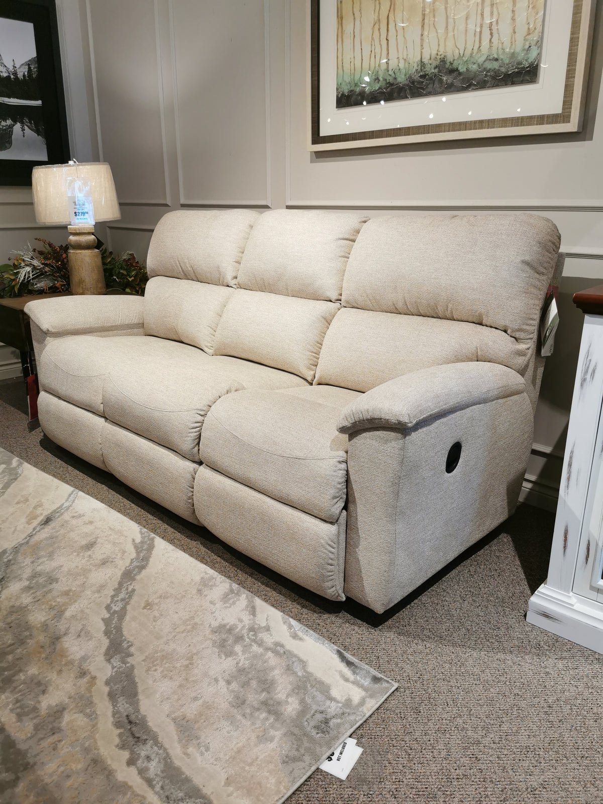 The La-z-boy 727 Brooks Reclining Sofa brings comfort to living rooms with a lamp and framed artwork.