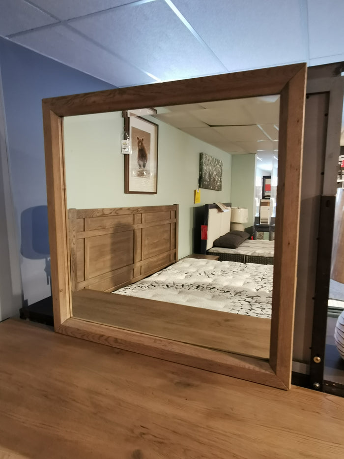 Vaughan Bassett's 123 Custom express Mirror showcases solid American white oak with a driftwood grey finish in a bedroom setup.