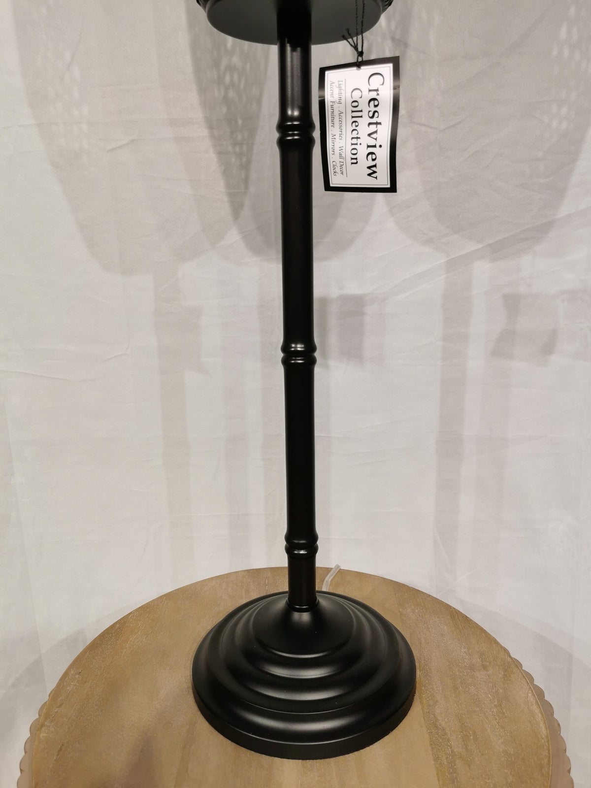 The "Crestview Collection" Rattan Floor Lamp adds a modern touch with its black metal stand and round wooden base.