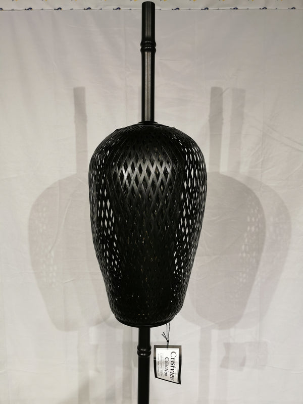 The Crestview Collection Rattan Floor Lamp casts a coastal shadow on white with its black woven design.