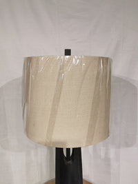 A beige fabric shade on a black stand, wrapped in plastic, features the Crestview Collection's Alterna Table Lamp.