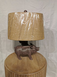 Crestview Collection's Hogs Fly Table Lamp features a pig base and textured shade, ideal for rustic decor.