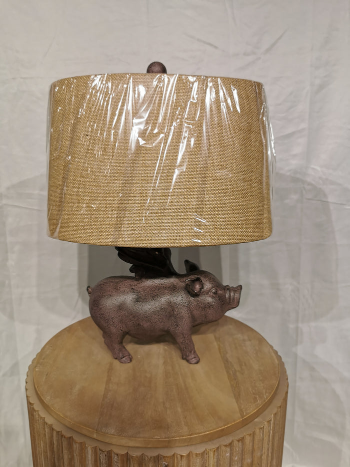 Crestview Collection's Hogs Fly Table Lamp features a pig base and textured shade, ideal for rustic decor.